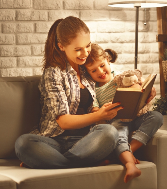 a mother reading a book to her child after having maintenance performed on their heat pump